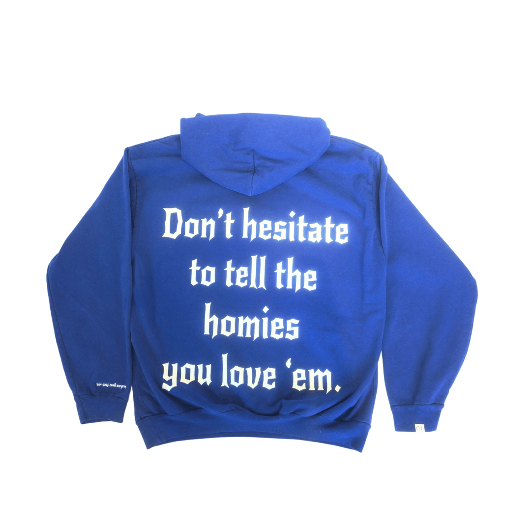 Blue hoodie with "Don't hesitate to tell the homies you love 'em" message in white text, made from organic cotton, sustainable and comfortable.